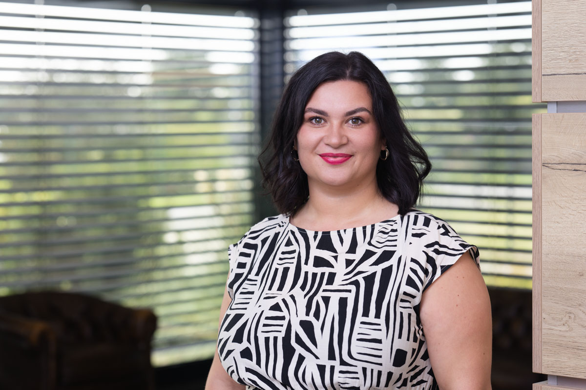 Freundliches Porträt einer Frau im Büro, natürliche Beleuchtung, modernes Arbeitsumfeld, Wohnquartier.