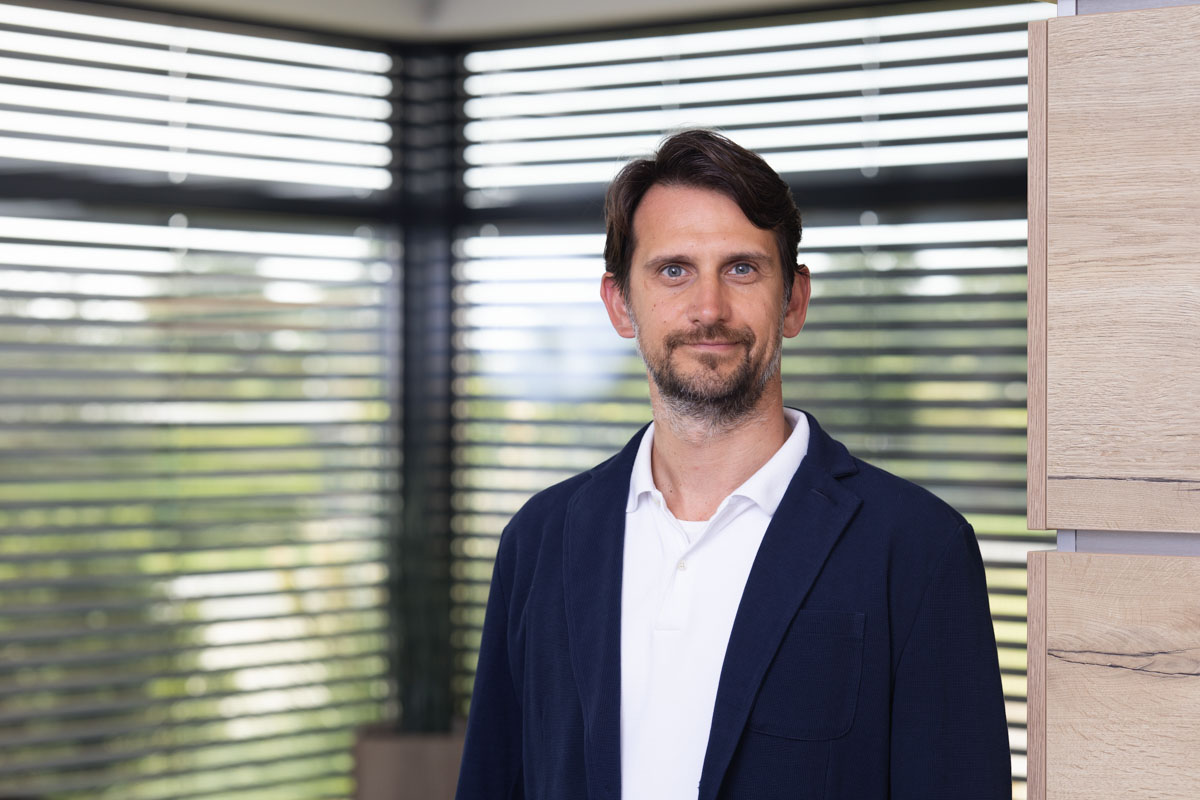 Freundliches Porträt einer Frau im Büro, natürliche Beleuchtung, modernes Arbeitsumfeld, Wohnquartier.