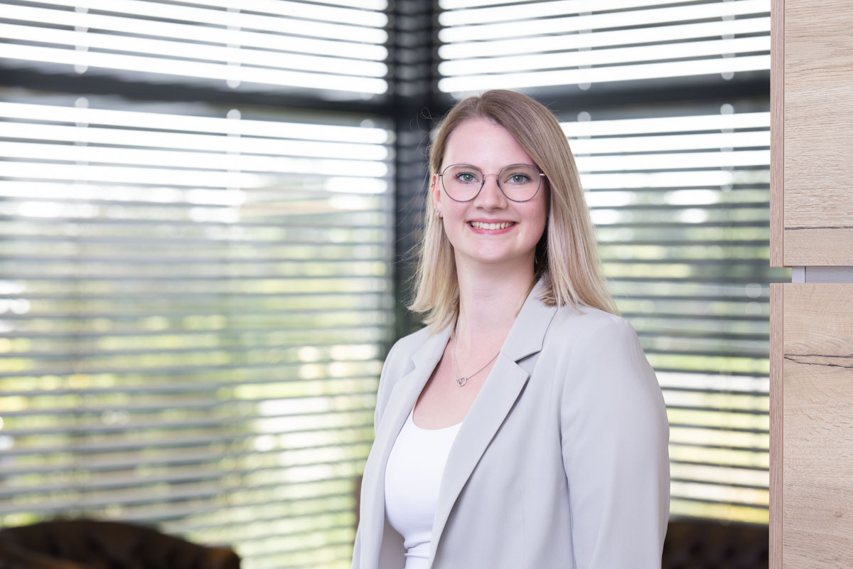 Freundliches Porträt einer Frau im Büro, natürliche Beleuchtung, modernes Arbeitsumfeld, Wohnquartier.