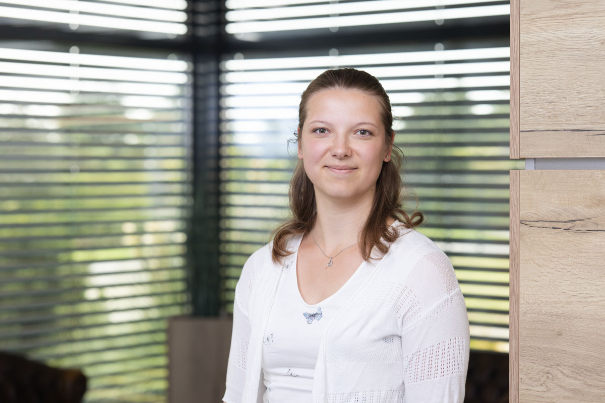 Freundliches Porträt einer Frau im Büro, natürliche Beleuchtung, modernes Arbeitsumfeld, Wohnquartier.