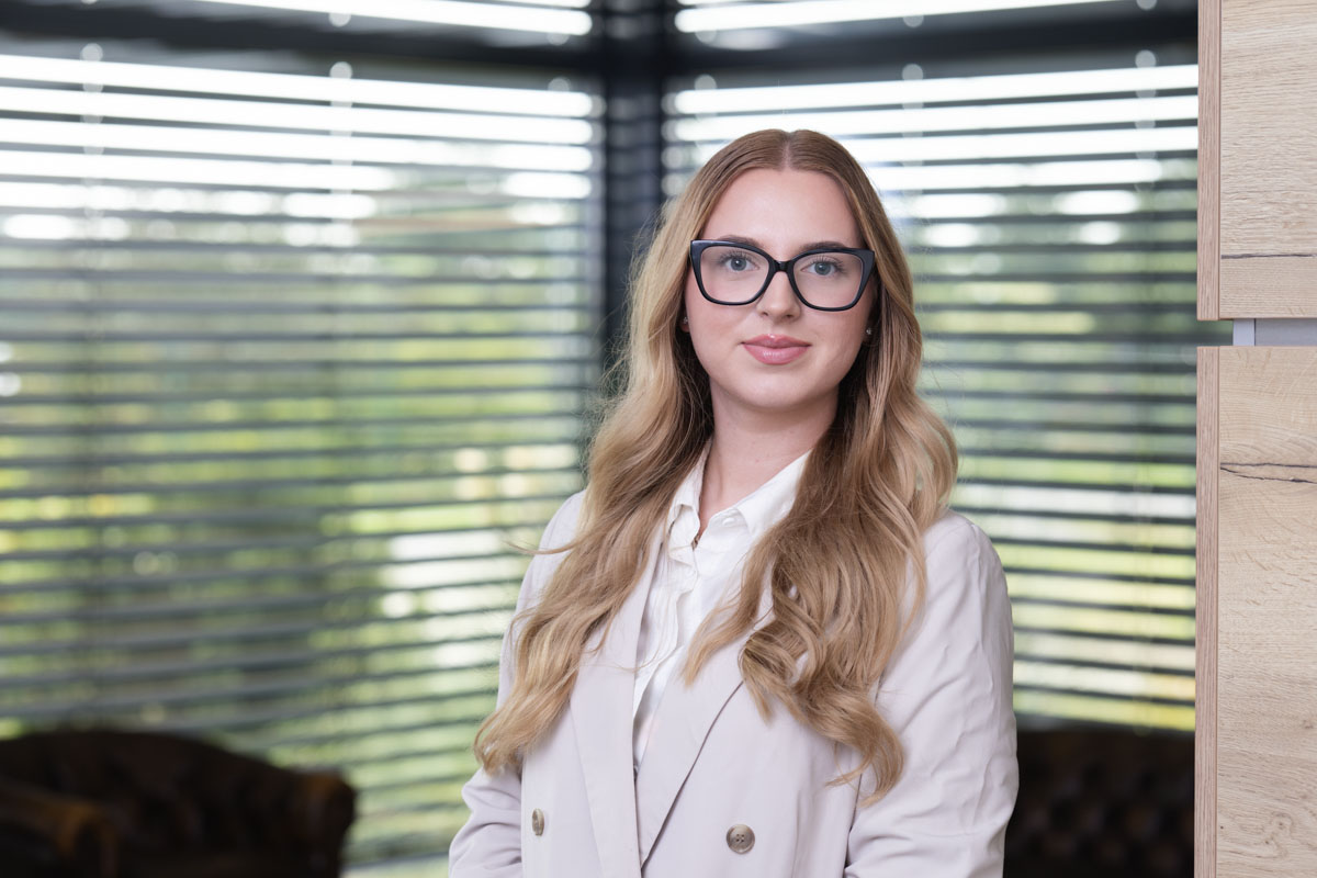 Freundliches Porträt einer Frau im Büro, natürliche Beleuchtung, modernes Arbeitsumfeld, Wohnquartier.